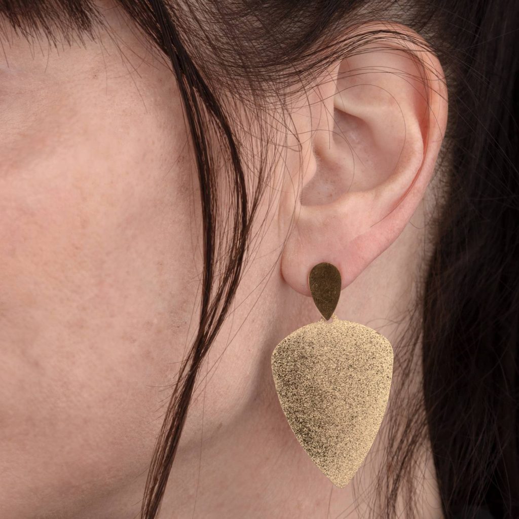 עגיל זהב קטן על אוזן דוגמנית בצילום תקריב