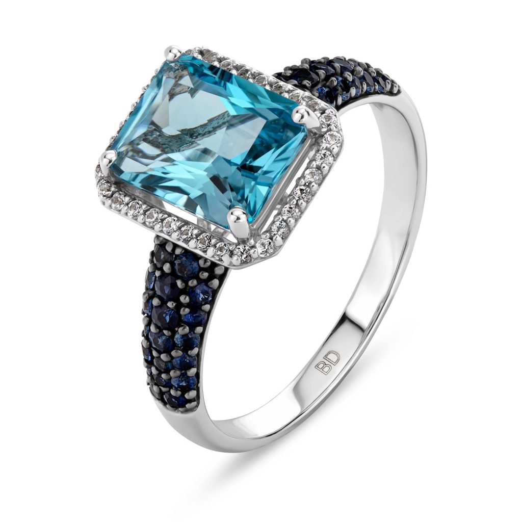 טבעת עם אבן כחולה מונחת בקופסה לבנהת